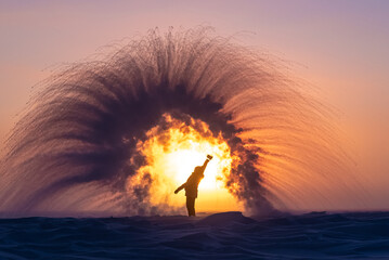 Person in full winter clothing throws a pitcher of boiling water into the air, creating rapid...