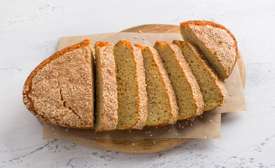 Delicious healthy gluten free lentil bread without flour with sesame seeds in a white baking dish on a light gray background. homemade vegetarian food