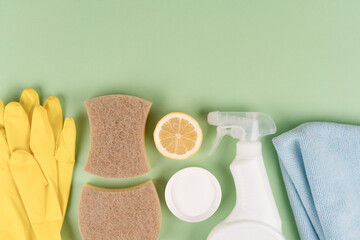 Green household concept. Bio organic detergent products, homemade cleaning detergents. Natural household cleaners  over green background with copy space. Homemade improvised cleaning products - obrazy, fototapety, plakaty