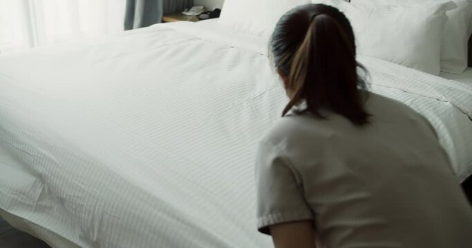 Employees, two maids of the hotel, professionally make the bed in the client's room. Five-star hotel concept and quality room service. Womans changing the bedding in the room.