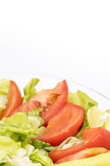 Fresh salad with tomato letuce and paprika served in the bowl with white background