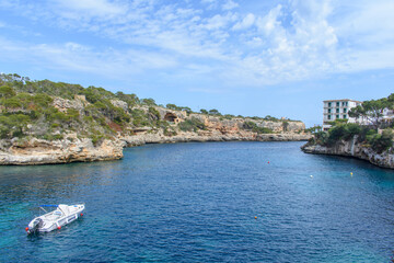 Fototapeta premium Landscape of Cala Figuera bay and motorboat in blue water