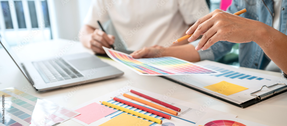 Aufkleber Two creative graphic designer team working on color selection and drawing on graphic tablet, Color swatch samples chart for selection coloring in inspiration to creativity at workplace