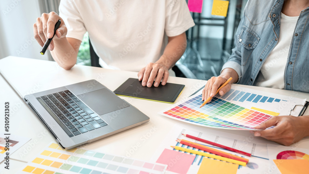 Aufkleber Two creative graphic designer team working on color selection and drawing on graphic tablet, Color swatch samples chart for selection coloring in inspiration to creativity at workplace