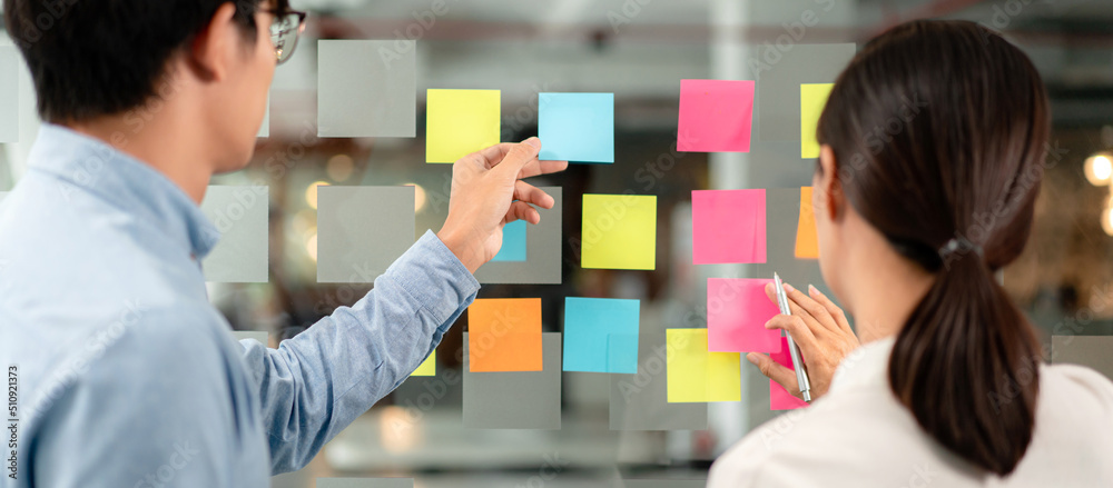 Poster two business executive team holding and taking notes keyword on board wall to brainstorm about a new