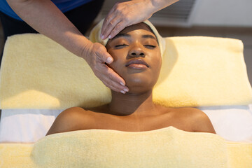 african woman in yellow towel on facial massage