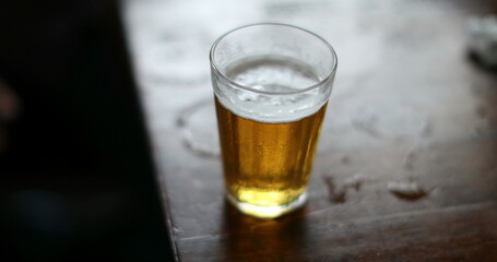 Picking up glass beer close-up of table. Person taking alchohol drink