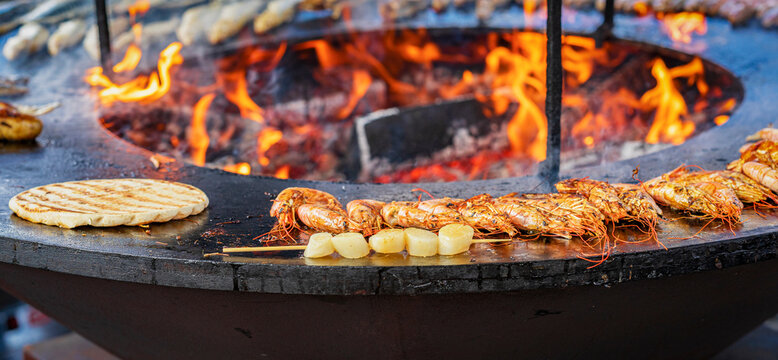 Preparing of seafood outdoors, prepared on bbq grill with fire flame