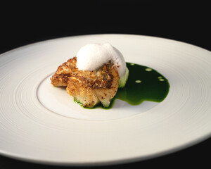 fried fish with green sauce and foam on white plate