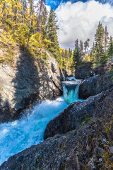 Natural rock waterfall in Yukon Territory near Alaska in September, fall season. 