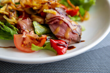 Salad with roast beef in a white plate. Traditional cuisine.