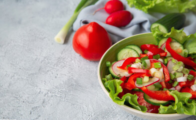 Fresh vegetable salad and various vegetables on the table with copy space. Healthy food rich in vitamins and fiber. Vegetarian food.