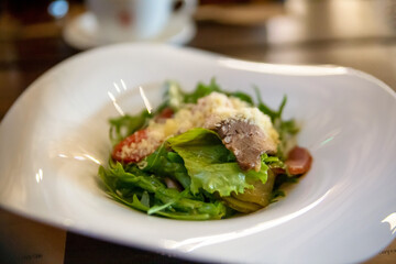 Salad with roast beef in a white plate. Traditional cuisine.