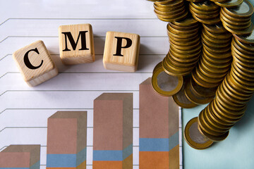 CMP - acronym on a green sheet on the background of a graph, pencils and coins