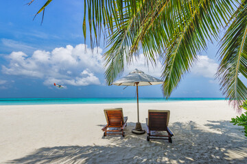 Summer vacation beach, travel scenic. Closeup couple chairs umbrella under palm trees, leaves. Sea sand sky, idyllic recreational landscape. Sunny beautiful tropical island landscape. Amazing paradise
