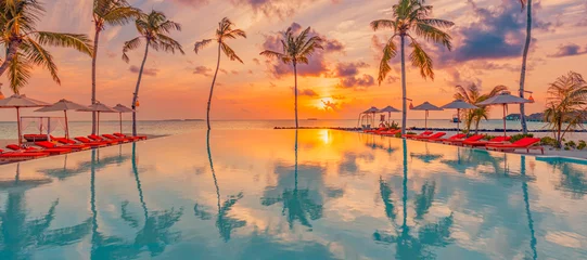 Luxus-Sonnenuntergang über Infinity-Pool schöne Strandresort tropische Landschaft. Panoramischer Strand, Sommerferienhintergrund. Erstaunliche Aussicht auf den Strand bei Sonnenuntergang, Palmen-Swimmingpool-Reflexion © icemanphotos