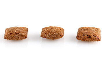 Set of chocolate pillows for breakfast isolated on white background. Brown choco cereal pads with vanilla, crispy flakes, healthy sweet snack. Close-up