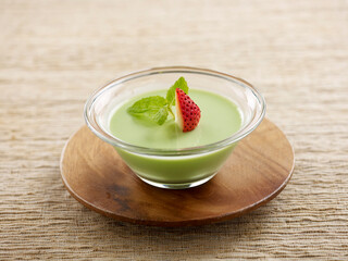Avocado Pudding Served in a bowl isolated on wooden board side view on grey background
