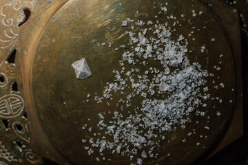 Maldon sea salt flakes with single pyramid shape salt crystal on hexagonal brass