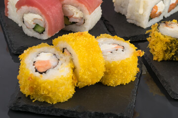 breaded fish stuffed rolls on a black stand