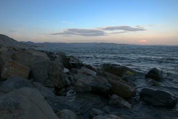 Coast of the Black Sea at sunset. Summer late evening. Beautiful seascape. Blue sky, steep cliffs, endless sea. Panoramic view. Russia.