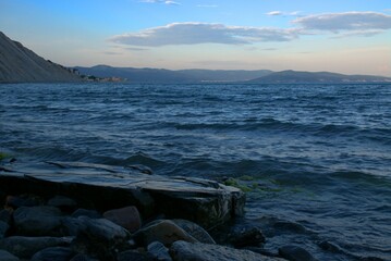 Coast of the Black Sea at sunset. Summer late evening. Beautiful seascape. Blue sky, steep cliffs, endless sea. Panoramic view. Russia.