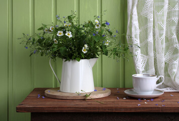 flowers in a jug in a rustic interior. cottage core.
