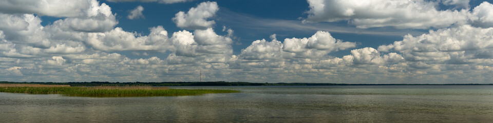 summer lake landscape with cloudy blue sky over the water. beautiful widescreen panoramic view