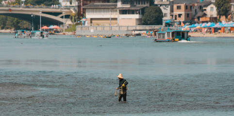 minimalist style photography of an unrecognizable chinese fisherman on the li river in china in a...