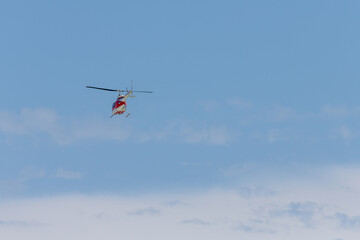 Fototapeta na wymiar Helicopter Flying into a Blue Sky