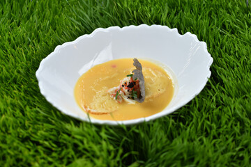 A dish of Italian cuisine corn soup with crab in a white plate