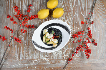 A dish of risotto with cuttlefish and artichokes in a white plate