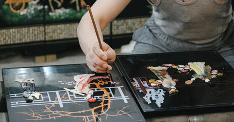 picture of a chinese craftsman making a hand painting on a tile in china