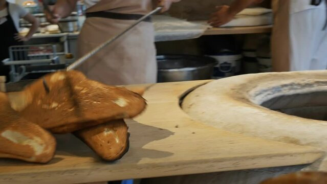 the baker takes out the baked ojakhuri from the tandoor with special long hooks and puts it on the table. National Georgian bread