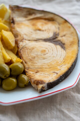 Seafood dish, grilled steak from swordfish or spada served with french fried potatoes and green olives