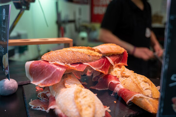 Spanish street food, bocadillo bread sandwich dry-cured ham jamon serrano close up