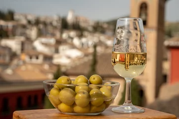 Fotobehang Tasting of Spanish sweet and dry fortified Vino de Jerez sherry wine and green olives with view on roofs and houses of old andalusian town © barmalini