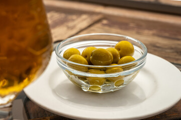 Glass bowl with green andalusian olives served on outdoor terrace in Andalusia, Spain