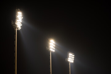 Stadium lights on in the rain at dark night