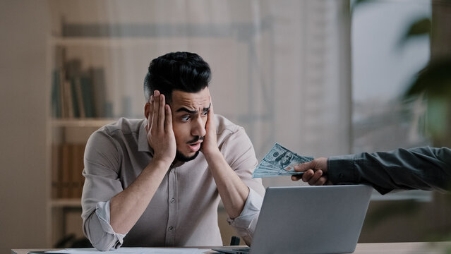 Desperate stressful arabic hispanic businessman male bookkeeper financial analyst read debt document papers find mistake feel shock young man get monetary bonus dollars banknote salary for motivation