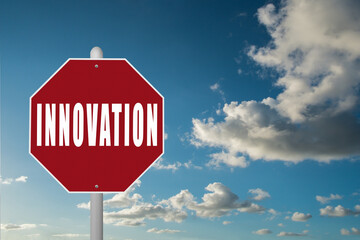 Red stop sign with the word Innovation on a blue sky background.