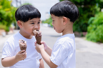 Child have enjoy for eating chocolate ice cream. Little boy eating an ice cream outdoors