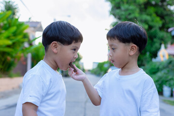 Child have enjoy for eating chocolate wafer. Little boy eating a wafer outdoors