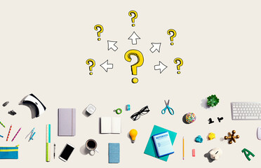 Big and small question marks with arrows with collection of electronic gadgets and office supplies