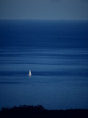 Fototapeta premium Sailboat in the sea, the coast is not too far.