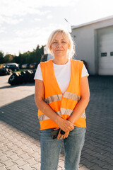 Close up portrait of worker engineer woman with orange vest. Female truck driver 