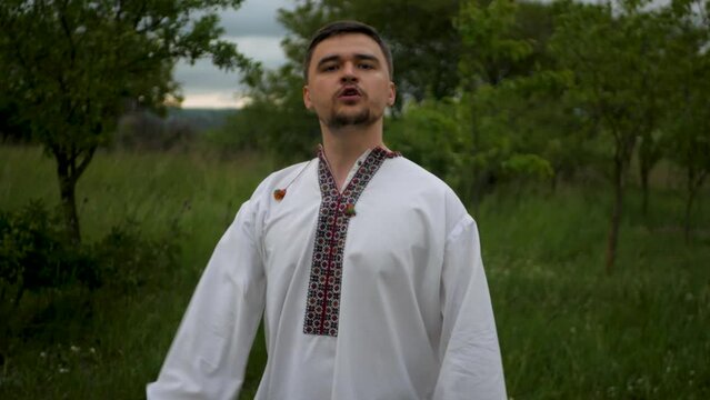 Serious and motivated caucasian man in traditional Ukrainian embroidered vyshyvanka showing fist and strength. Concept of not giving up with willpower and continuing to fight the enemy at all costs
