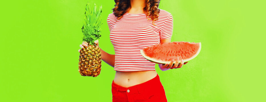 Close up of beautiful slim woman with pineapple and slice of watermelon on green background