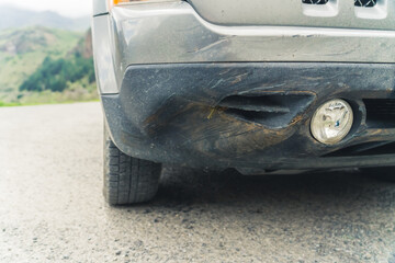 Outdoor closeup shot of a dented bumper of a car vehicle. Danger of road accidents. High quality...