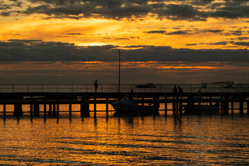 Fototapeta na wymiar An sunset by the ocean with a jetty, in Melbourne Victoria.